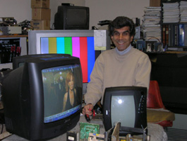 Shop owner with television sets